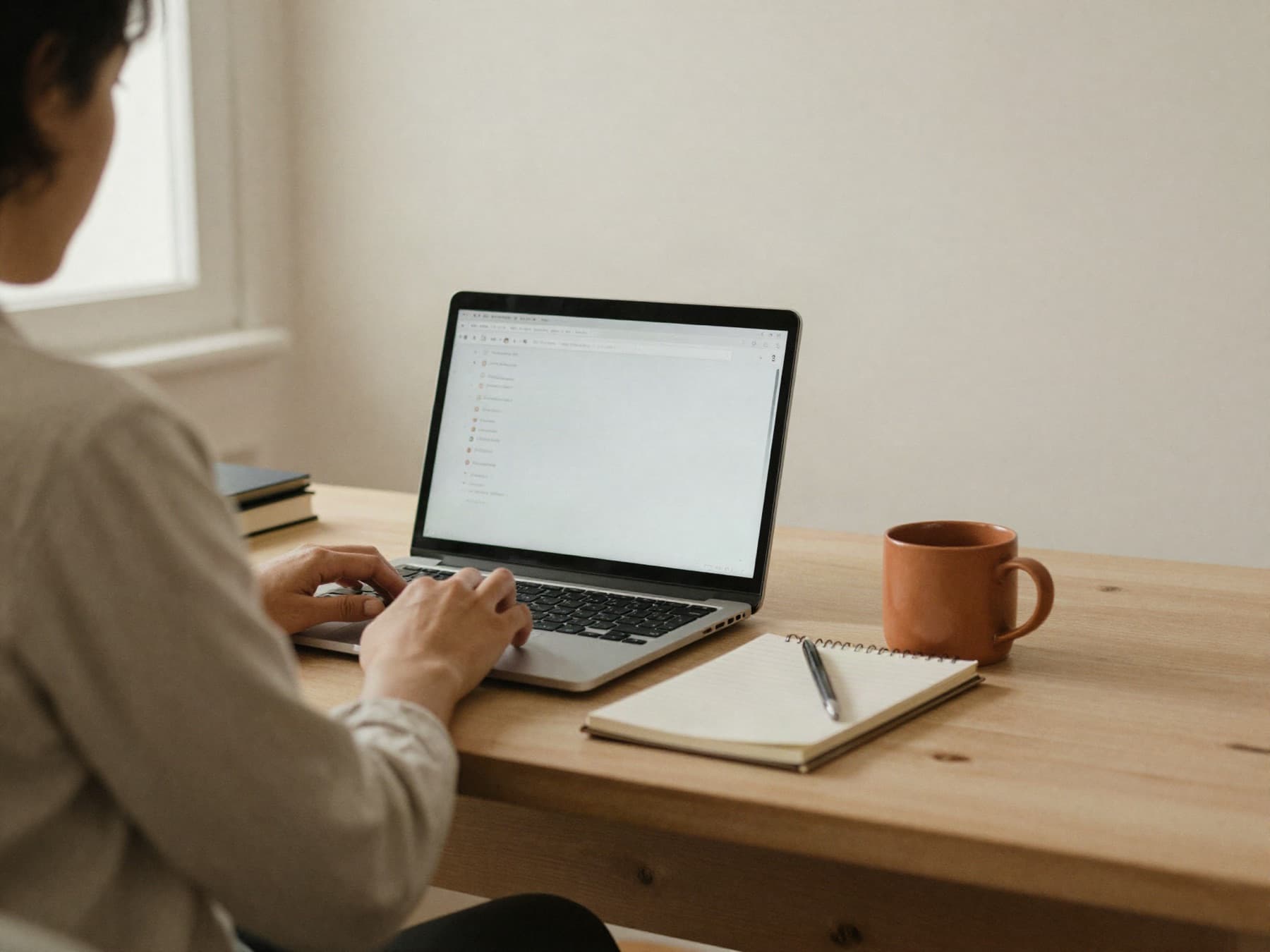 Someone working at a laptop in a warm, quiet room